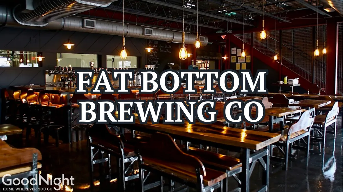 The interior of a local brewery, with communal tables, a bar area, and warm pendant lighting creating a friendly, sociable setting ideal for tasting craft beers and meeting friends.