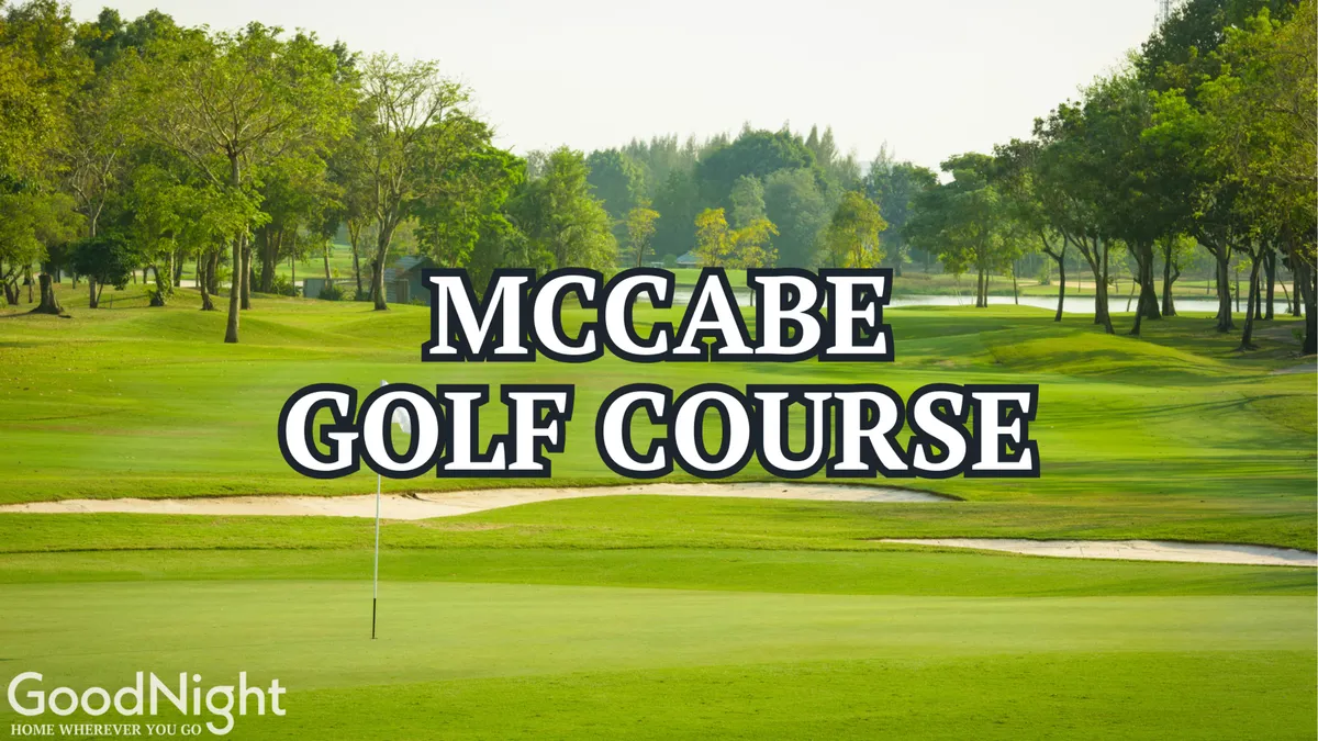 A scenic view of golf course greens with a golf flag fluttering in the breeze and mature trees in the background. The tranquil setting is ideal for outdoor recreation, highlighting the opportunity for golfing, leisurely walks, picnics, and relaxation just minutes from the property.